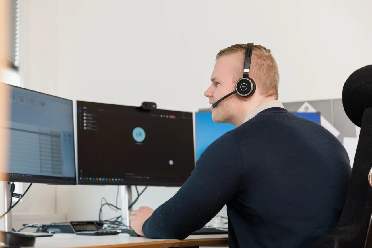 Rådgiver hos Devold Consulting i arbeid ved skjermene på kontoret